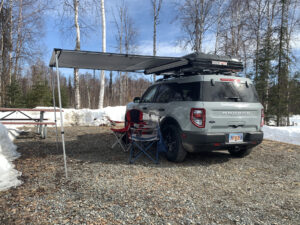 Spring camping in a Travel SUV with awning open and snow on the ground